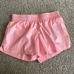 Standard fit pink Nike running shorts with gold detail. NWT